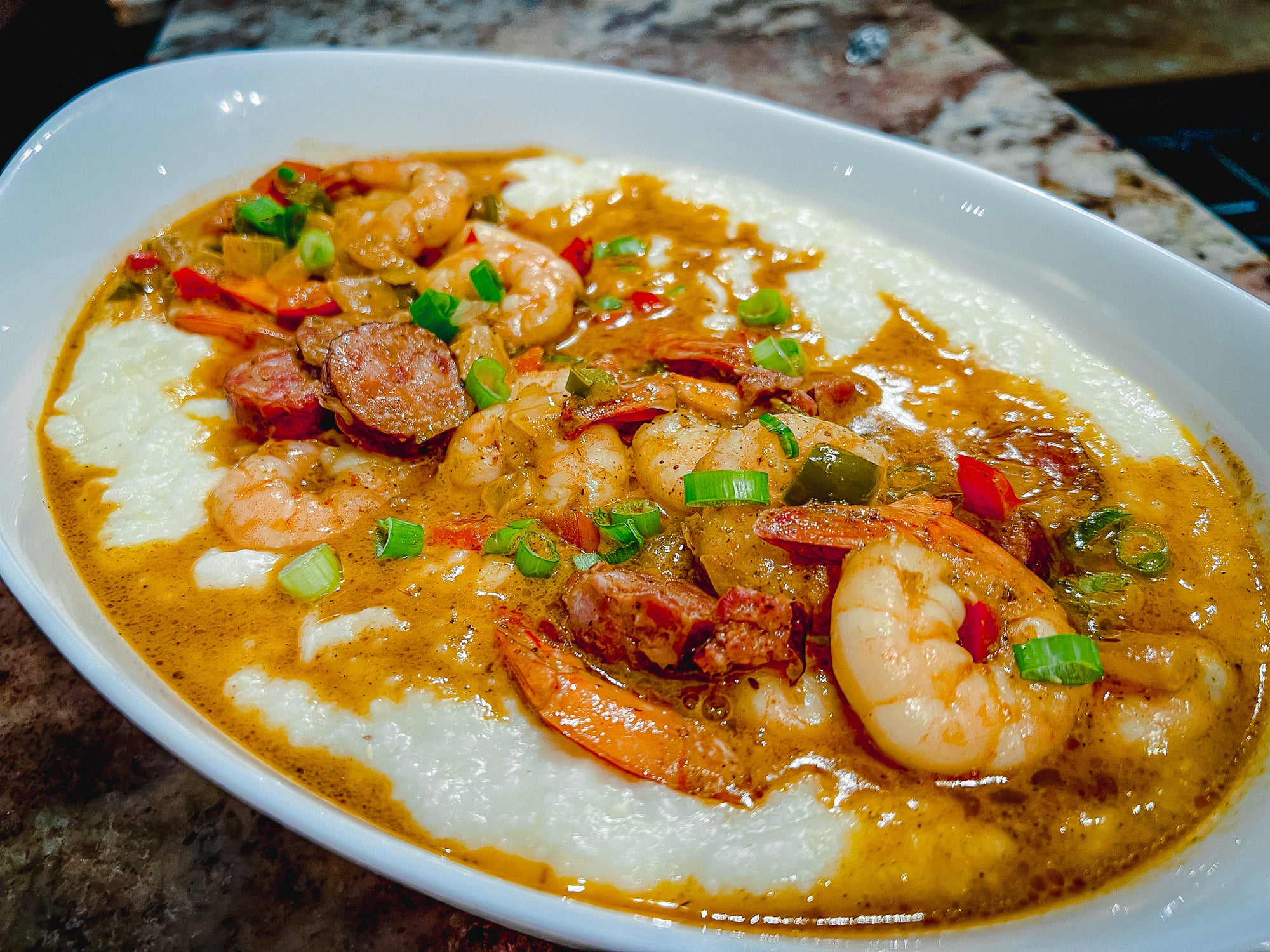 shrimp and grits covered in creamy sauce in a white bowl